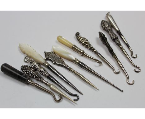 Seven small button hooks (5 with silver handles) and 4 manicure implements.