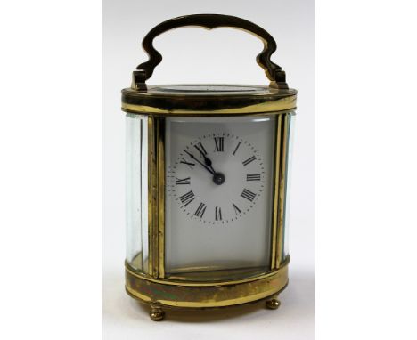 Five glass oval shaped brass carriage clock with black Roman numerals on a white face approx height not including handle 10.5