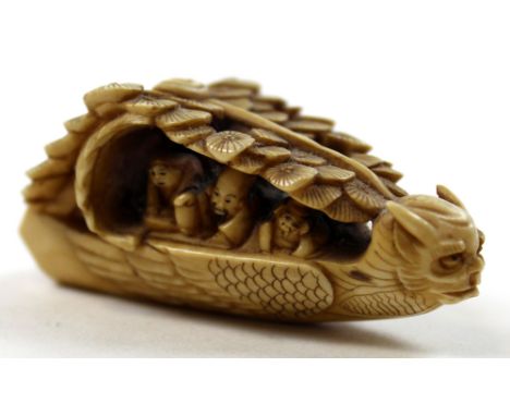 Japanese ivory netsuke depicting figures in a boat shaped like a serpent, length approx 5.5cm and signed on base