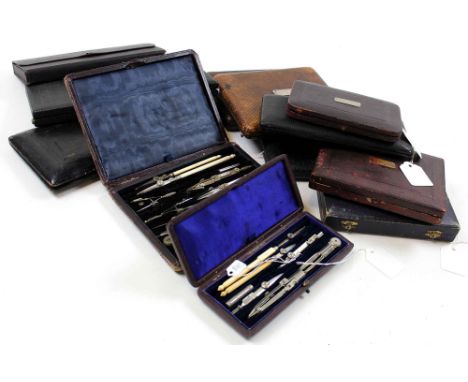 Twelve compass sets, all in leather cases