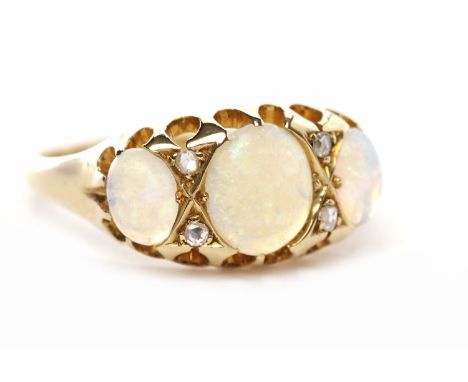 EARLY TWENTIETH CENTURY OPAL AND DIAMOND RINGin the Victorian style, set with three oval cabochon cut opals interspaced by ro