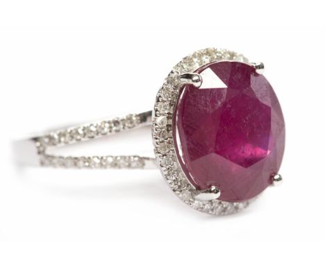 RUBY AND DIAMOND DRESS RINGset with a single oval ruby of approximately 6.25 carats, surrounded by diamonds, on diamond set b