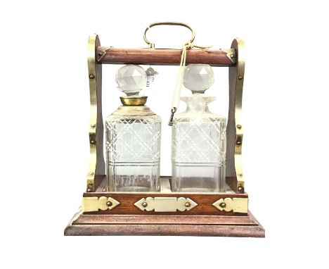 MAHOGANY AND BRASS BOUND TANTALUS, with two decanters32cm x 30 cm