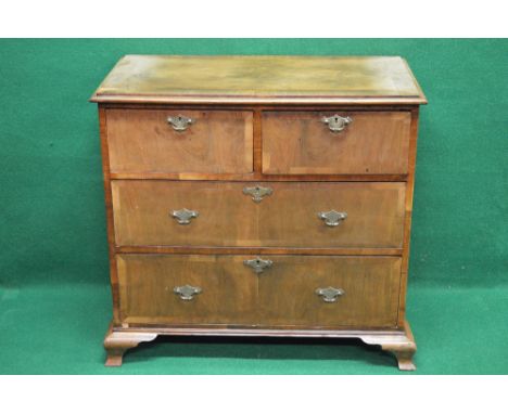 Walnut chest of four drawers with moulded top over two short and two long drawers with brass handles and escutcheons, standin
