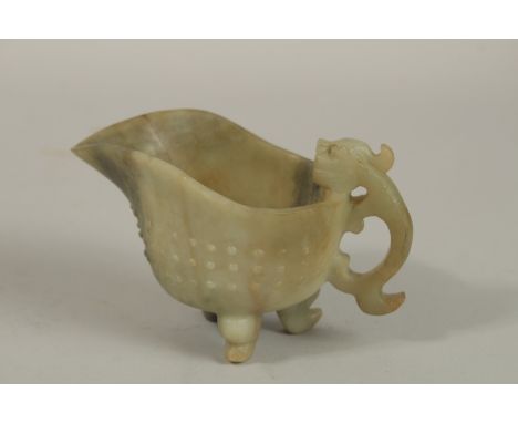 A CHINESE CARVED JADE OR GREEN HARDSTONE RITUAL JUG, with carved chilong handle and tripod legs, 13cm spout to handle.