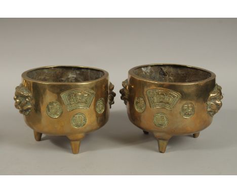 A PAIR OF 19TH CENTURY CHINESE GILT BRONZE TRIPOD CENSERS, with lion-form handles and calligraphy panels, the base with round