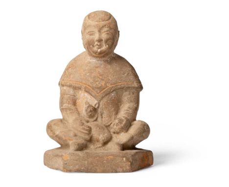 POTTERY FIGURE OF A BOY HOLDING RABBIT SONG DYNASTY 宋 紅陶童子抱兔俑 naturalistically moulded in a seated posture on a hexagonal bas