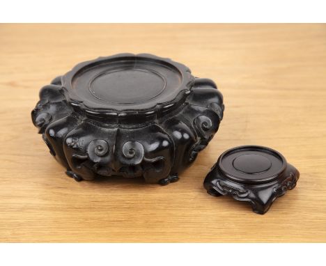 Two Zitan wood standsChinesethe smaller square stand, with ruyi carving, overall width 8.5cm, and a larger lotus-shaped stand
