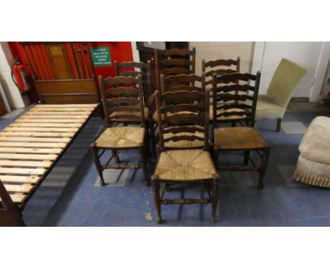 A Set of Seven Rush Seated Ladder Back Oak Dining Chairs to Include One Carver 
