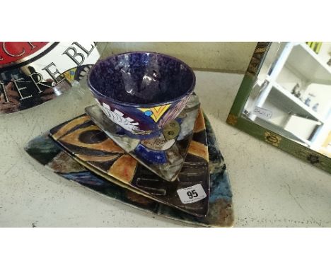 A set of four Karen Brown triangular ceramic plates decorated in various abstract patterns in tones of orange, green, blue an