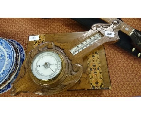 A marquetry inlaid work box containing various cutlery items together with an oak cased barometer.