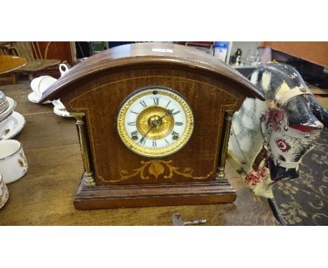 An Edwardian inlaid mahogany mantle clock with brass pillar supports to front.