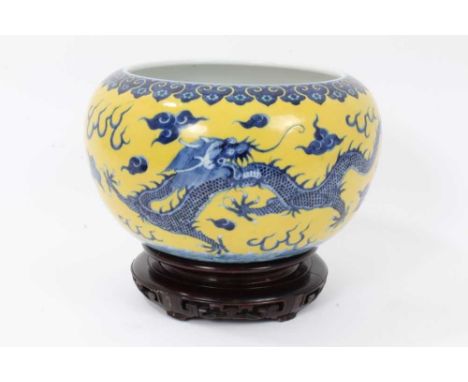 Chinese yellow-ground porcelain alms bowl, decorated in underglaze blue with dragons chasing a flaming pearl, Qianlong seal m