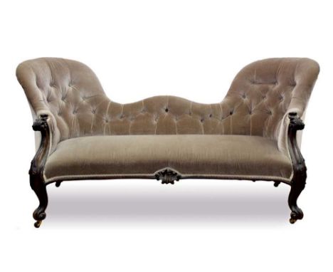 Victorian mahogany framed sofa, with button velvet upholstered shaped back on scroll carved supports and castors