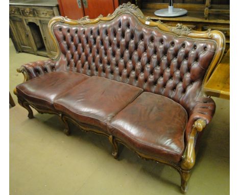 A French style button back leather upholstered salon sofa, with carved showwood raised on cabriole legs, (retailed by World o