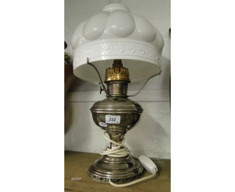 An oil lamp with milk glass shade