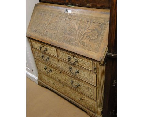 A large Antique carved oak bureau, with a fitted interior, 2 short and 3 long graduated drawers under, bracket feet, width 3'