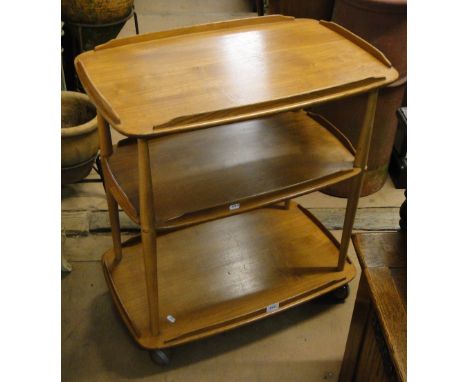 An Ercol light elm 3-tier tea trolley on castors.