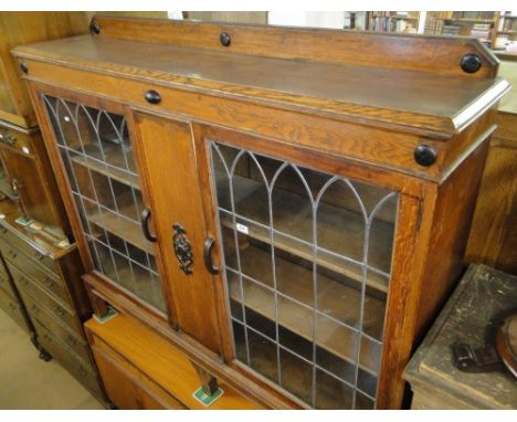 A 1920s oak bookcase with 2 lead light glazed panelled doors.