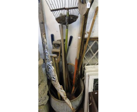 Continental galvanised wash bucket, a wrought-iron bracket and a quantity of long handled gardening tools.