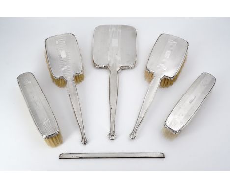 An early George VI silver dressing table mirror and brush set, of Art Deco design, comprising two hair brushes, two clothes b