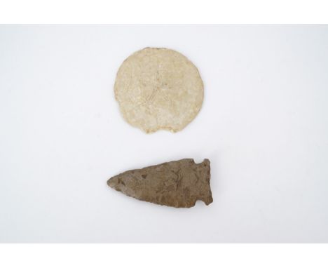 A stone arrowhead, Neolithic / early native American, together with a fossil urchin, former 5 cm