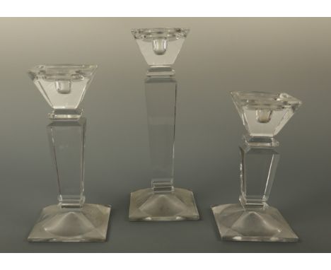 Three contemporary pressed glass statement candlestick holders, of graded height and square section, accommodating three diam
