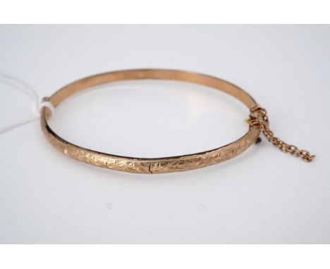 An Edwardian 9 ct gold hinged bangle, of foliate-engraved D-section, 60 mm x 47 mm, 5 g
