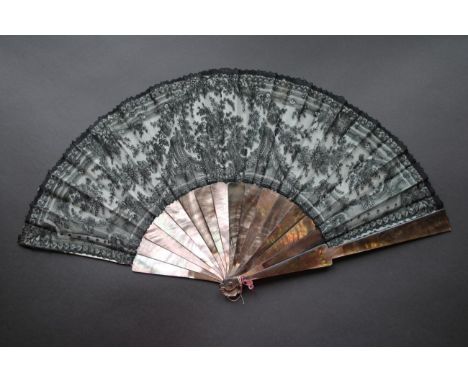 A Circa 1880's Black Lace Fan, Chantilly, mounted on dusky dark grey/mauve mother-of-pearl sticks, which continue as ribs, th