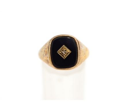 A 9 carat gold onyx and diamond set signet ring, the star set single cut to the centre of the cushion shaped onyx, finger siz