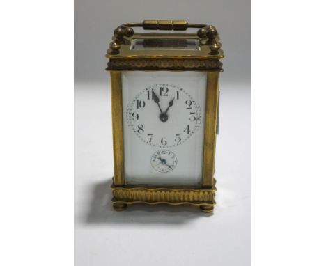 A small brass carriage clock, the enamel dial with subsidiary alarm, 13cm high including carrying handle
