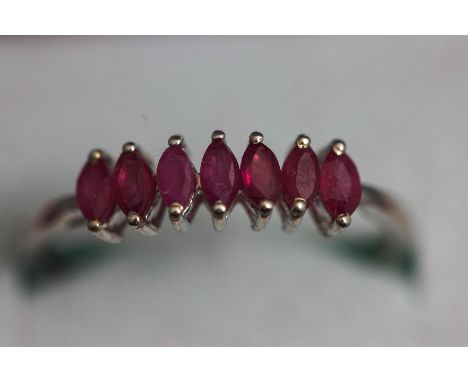 A seven stone ruby ring, the white mount stamped '9K 375', finger size R, 1.3 g gross, cased