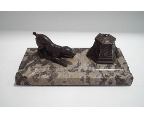 An Art Deco style marble and pewter desk stand, modelled with a dog and inkwell, 25cm wide