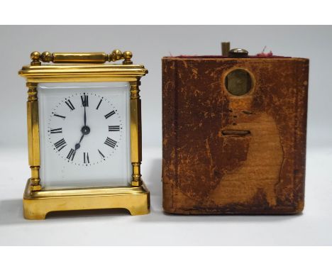 A brass cased carriage clock with leather travelling case and key, 13cm high