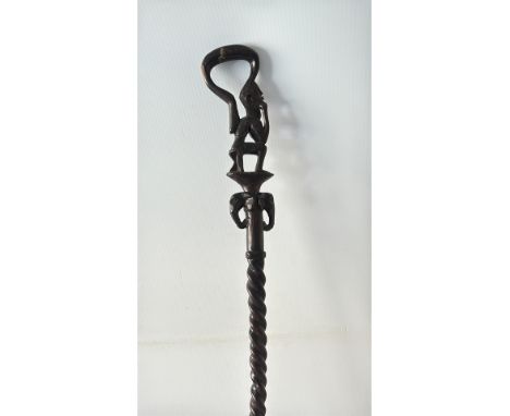 Hand-carved African wooden staff, featuring a contemplative figure and intricate detailing. A striking tribal art collectible
