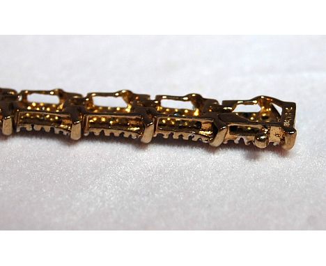 A 10 CT GOLD DIAMOND PANEL TENNIS BRACELET - THE 25 PANELS EACH SET WITH 9 DIAMONDS MARKED T.D.W. 1.9 (17.5CM)