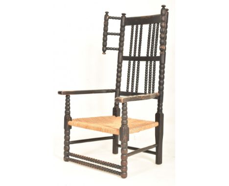 An Arts &amp; Crafts late 19th / early 20th century circa 1900 ebonised bobbin turned armchair. The chair having a rail backr