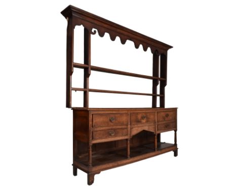 A matched George III early 19th century oak Welsh dresser. The sideboard dresser's wider top with flared pediment atop with s