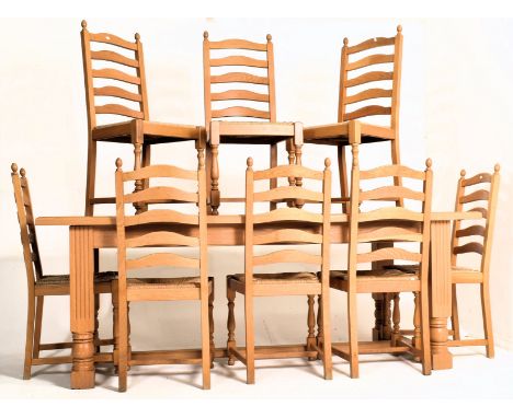 A large light oak 18th century revival refectory farmhouse dining table and eight chairs. The table having a rectangular top 