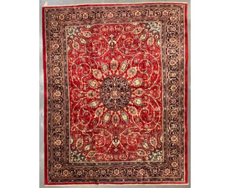 A large early 20th century North West Persian Islamic Sarouk floor carpet rug. The rug having a central flower shaped medalli