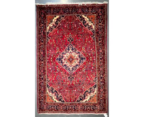 A 20th century North West Persian Islamic Sarouk floor carpet rug. The rug having a diamond shaped central medallion in orang