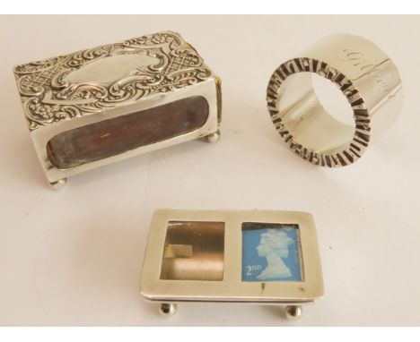 A silver group of three:a hallmarked silver matchbox holder, repoussé decoration and with vacant cartouche and C-scrolls;a sm