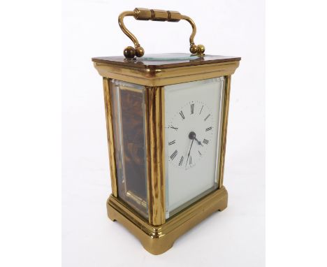 An English gilt-brass and glass-sided carriage clock timepiece: white enamel dial with Roman numerals and the gilded movement