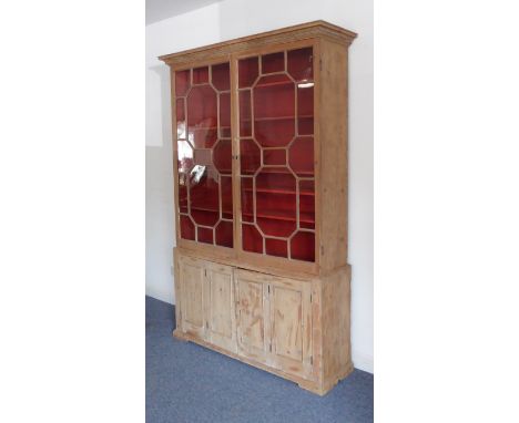 A probably late 18th century pine book or display case: the cornice with a key-fret pattern above two 15-pane panel doors wit