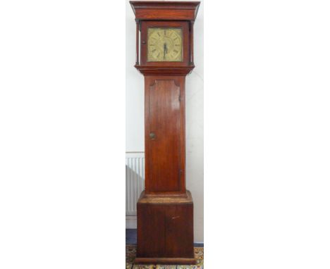 An early 19th century oak-cased longcase clock: outset cornice above an 11-inch brass dial flanked by turned columns; the dia