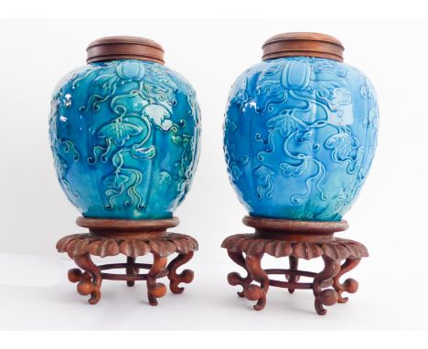 A pair of Chinese 19th century pottery ginger jars: turquoise glaze with trailing decoration in relief of fruits, peony and l