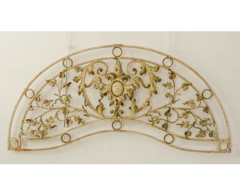 A decorative cast and wrought iron garden arch: central scrolling acanthus leaves surrounding a cartouche with a letter S and
