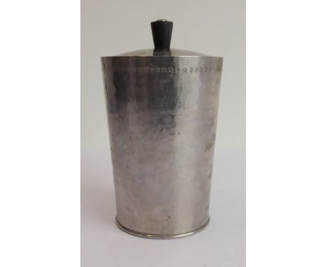 Keswick School of Industrial Art: a hand-planished pewter preserve pot and cover of conical form and with conforming ebony kn