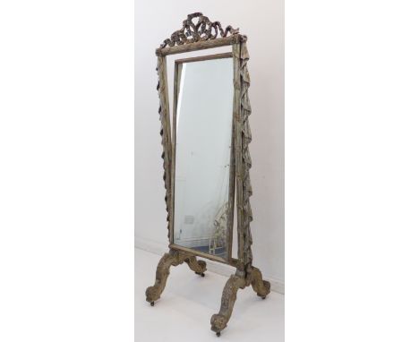 A late 19th to early 20th century Louis VI style silver-painted cheval mirror: pierced ribbon pediment above a rectangular pl