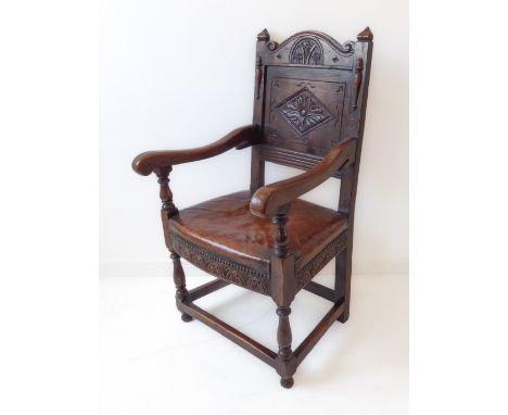 An&nbsp;oak panel-back chair in&nbsp;17th century style (probably early 20th century): the shaped top rail with scrolls; pane